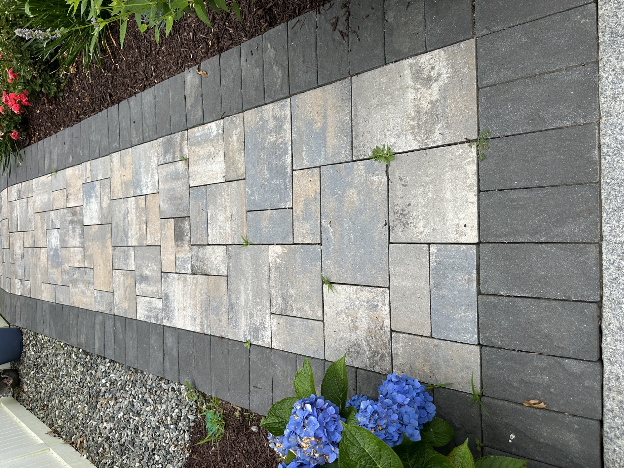 Finished paver walkway bordered by garden plantings